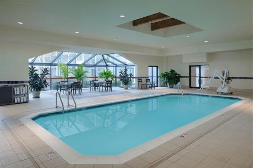 迈阿密斯堡代顿南购物中心万怡酒店的一座带桌椅的大型游泳池