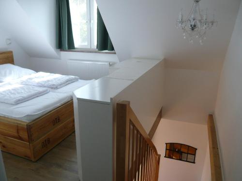 Neue Tiefe FehmarnAloha 2的一间卧室配有一张床,楼梯配有吊灯