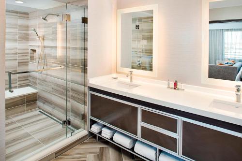 达拉斯Dallas Marriott Suites Medical/Market Center的一间带两个盥洗盆和淋浴的浴室