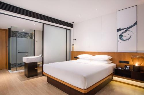佛山佛山新凯广场万枫酒店的卧室配有白色的床和水槽