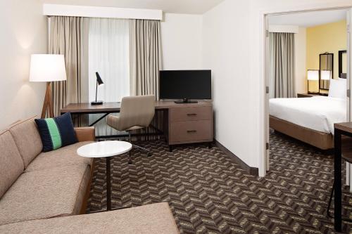 戴德姆波士顿戴德姆镇原住客栈的酒店客房设有沙发、床和电视。
