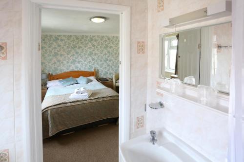 赖德怀特岛多西特住宿加早餐旅馆的一间卧室配有一张床和一个水槽和一个浴缸