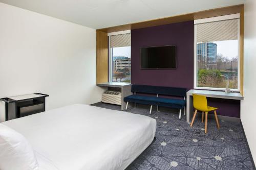 夏洛特夏洛特巴兰坦雅乐轩酒店的酒店客房配有一张床、一张书桌和一台电视。