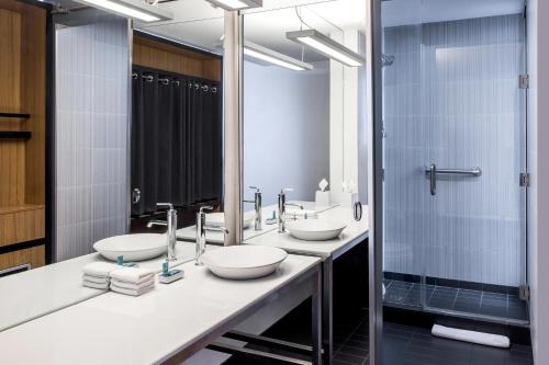 夏洛特夏洛特巴兰坦雅乐轩酒店的一间带两个盥洗盆和淋浴的浴室