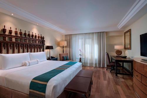 库斯科库斯科修道院万豪酒店的酒店客房设有一张大床和一张书桌。