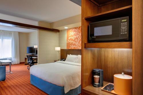 林垦林肯市东南万豪费尔菲尔德酒店的配有一张床和一台平面电视的酒店客房