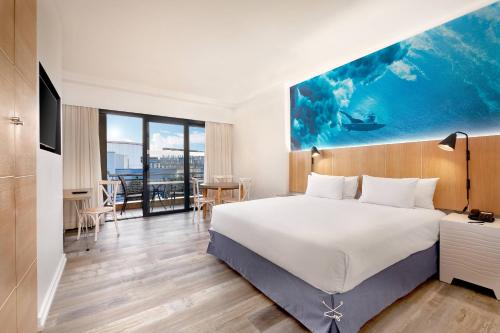 德班Protea Hotel Fire & Ice! by Marriott Durban Umhlanga Ridge的酒店客房设有一张大床和一张桌子。