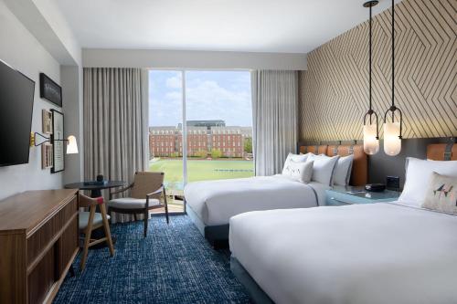 俄克拉何马城The Ellison, Oklahoma City, a Tribute Portfolio Hotel的酒店客房配有两张床和一张书桌