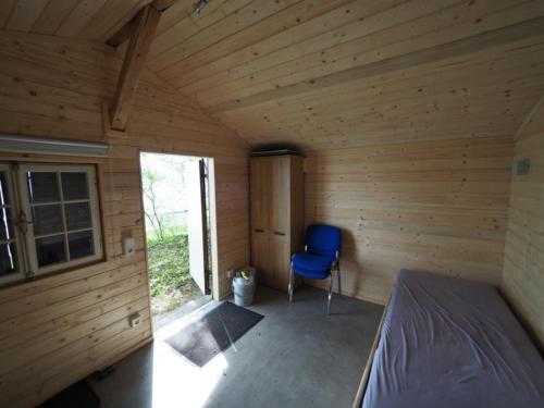 赖兴瑙Häuschen direkt am See的小木屋内的卧室,配有蓝色椅子