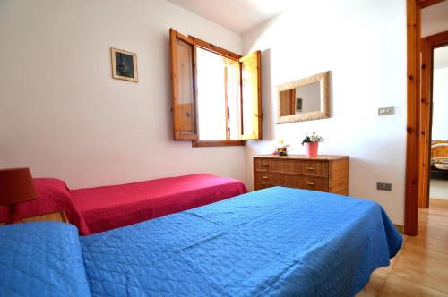 新福卡Casa vacanza vicino spiaggia-ll23的一间卧室配有蓝色的床、梳妆台和窗户。