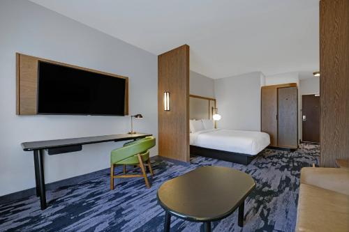 布鲁克菲尔德Fairfield Inn & Suites by Marriott Milwaukee Brookfield的酒店客房设有一张床和一张带电视的书桌。