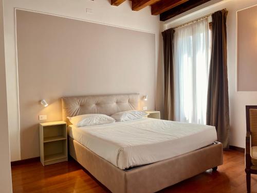 威尼斯科特罗莎酒店的一间卧室设有一张大床和一个窗户。