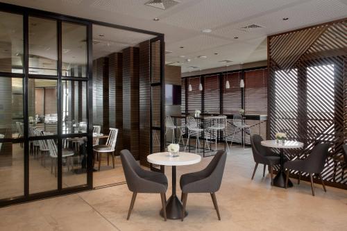 利马Fairfield by Marriott Lima Miraflores的用餐室设有桌椅和窗户。