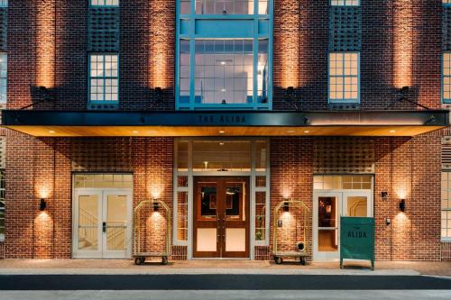 萨凡纳The Alida, Savannah, a Tribute Portfolio Hotel的砖砌的建筑,有两扇门和一个读工会的标志