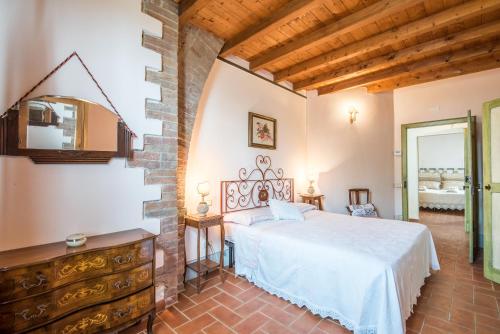 拉波拉诺泰尔梅Villa Il Fornacino的一间卧室设有一张床和石墙