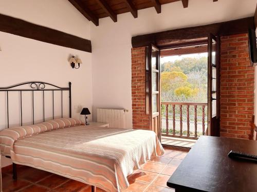 科布雷塞斯Apartamentos Camino del Norte的一间卧室设有一张床和一个大窗户
