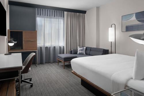 卡尔加里Courtyard by Marriott Calgary Downtown的配有一张床和一张书桌的酒店客房