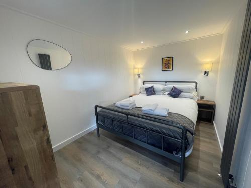 彭里斯Martindale & Fusedale Lodge的卧室配有一张壁挂镜子的床