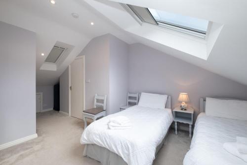 克利夫登Cottage 420 - Clifden的白色客房的两张床,设有窗户