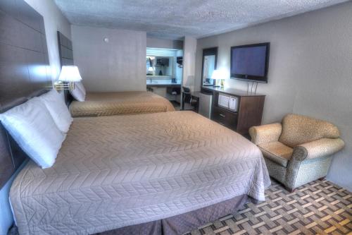 海伦Amerivu Inn & Suites - Helen - Downtown的酒店客房,配有两张床和椅子