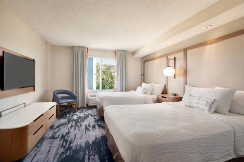 斯帕克斯Fairfield Inn & Suites by Marriott Reno Sparks的酒店客房设有两张床和一台平面电视。
