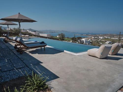 KrotiriOlithos Villas的一个带2把躺椅和遮阳伞的游泳池