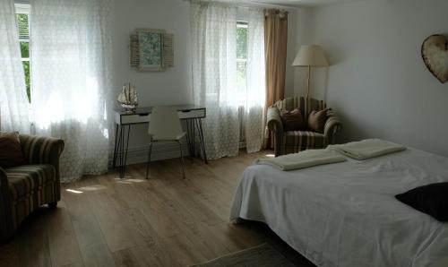 克伦胡森Altes Zollamt - Sünnschien的卧室配有一张床和一张桌子及椅子