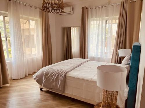 普拉伊拉多比莱尼Casa Conforto Bilene的一间卧室设有床、窗户和一盏灯。