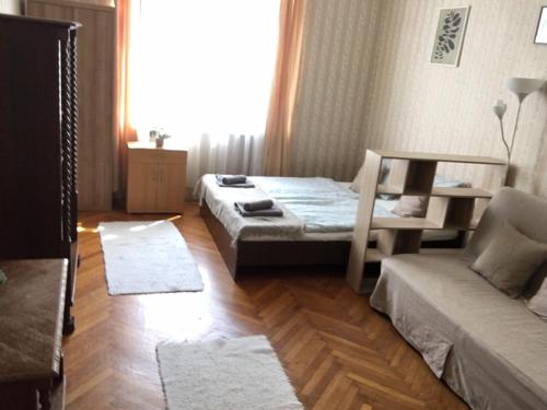 布达佩斯Cozy flat at Stadionok M station的一间卧室设有两张床、一张沙发和一个窗口