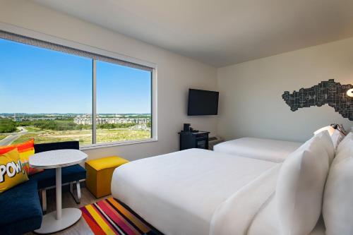 圣安东尼奥Aloft San Antonio UTSA Area的酒店客房设有两张床和大窗户。