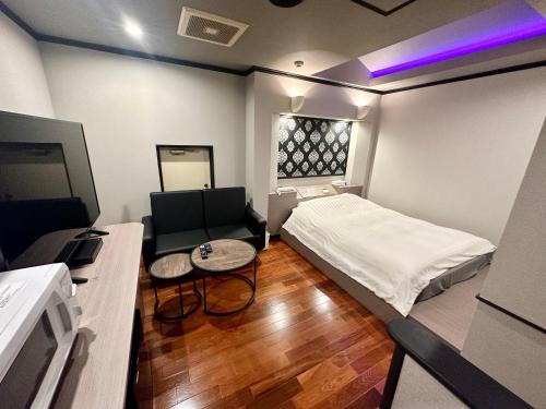 横滨grandir ｸﾞﾗﾝﾃﾞｨｰﾙ-Adult Only-的小房间设有床和沙发