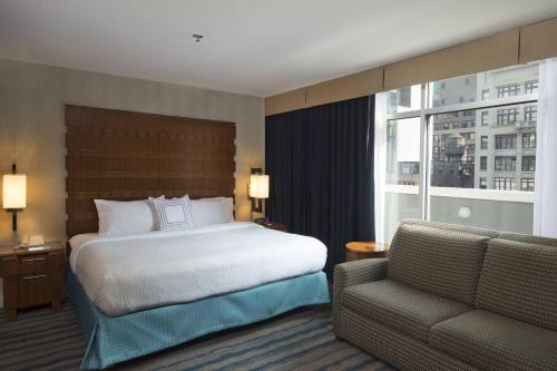 纽约纽约曼哈顿/第五大道万豪费尔菲尔德酒店的一间卧室配有一张床、一张沙发和一个窗口