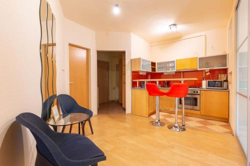 布达佩斯M36 Mester Apartment的厨房配有橙色和蓝色的椅子和桌子