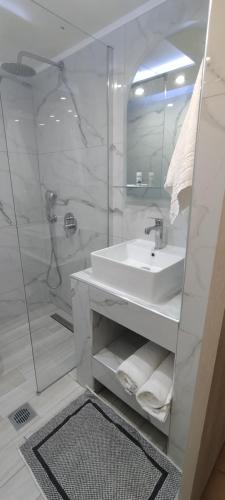 科斯镇Sweetmar Rooms-Ground floor的白色的浴室设有水槽和淋浴。