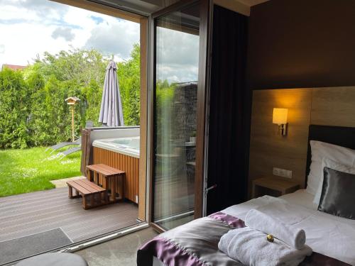 凯斯特海伊Villa Aruba & Private SPA Suites的一间卧室配有一张床,阳台配有遮阳伞