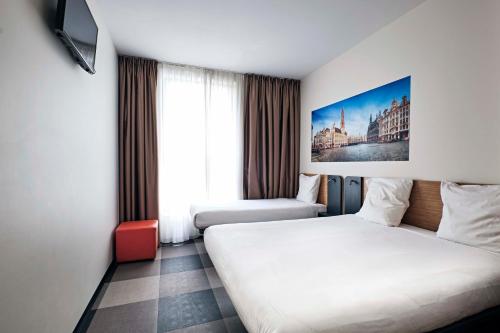 布鲁塞尔布鲁塞尔市中心便捷酒店的一间酒店客房,设有两张床和电视