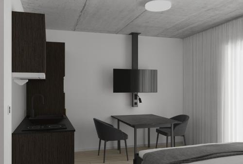 圣加仑MOOI Apartments St.Gallen的一间卧室配有书桌、一张床和一张桌子及椅子
