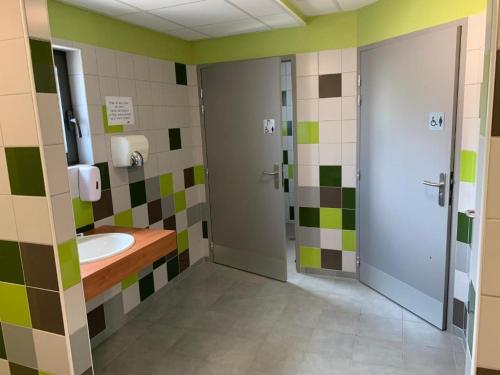 VirigninLes Lodges de la ViaRhôna - Tentes Lodges的浴室设有水槽和绿色及白色瓷砖