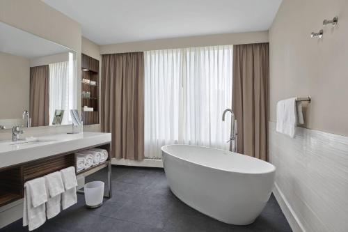 埃德蒙顿三角洲埃德蒙顿中心酒店的浴室配有大型白色浴缸和水槽