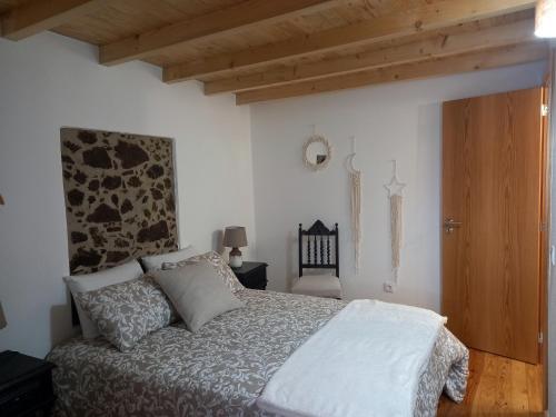 Barca da AmieiraAmieira do Tejo guest house的一间卧室设有一张床和木制天花板