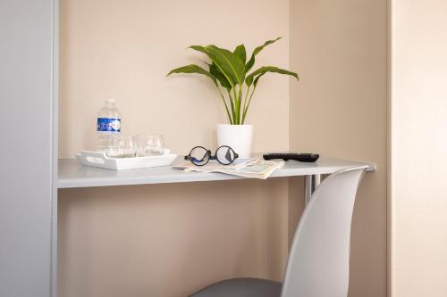 滨海利翁海狮酒店的白色桌子,上面有植物和眼镜