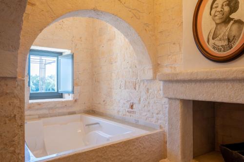奥斯图尼Masseria Santo Scalone的窗户客房内的白色浴缸
