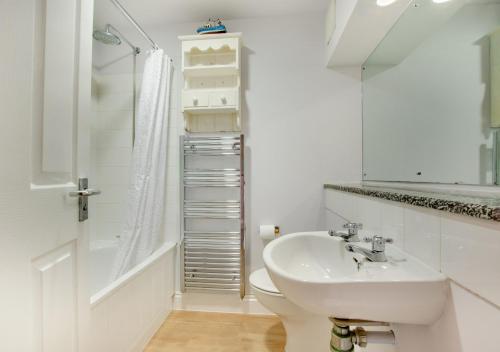 Saint LevanAquarius的白色的浴室设有水槽和淋浴。