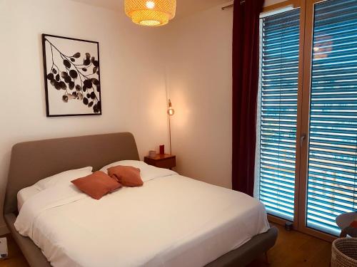 里昂Appartement T3 Confluence的卧室设有白色的床和大窗户