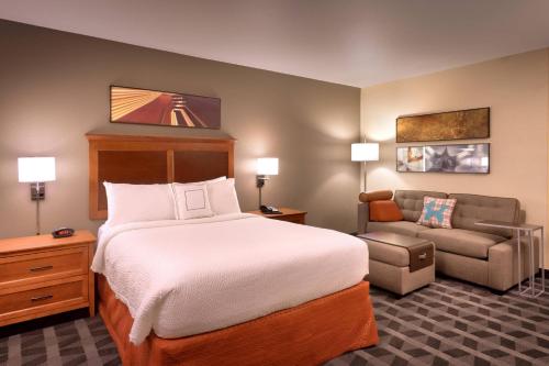 优马TownePlace Suites by Marriott Yuma的配有一张床和一把椅子的酒店客房