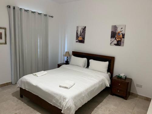 希法Apartment in Jebel Sifah的一间卧室配有一张床,上面有两条毛巾