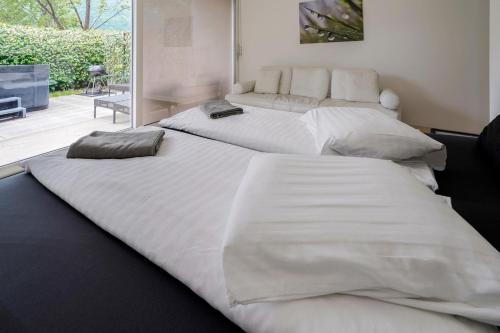 卡斯拉诺The Glass House & SPA的客房内的两张大型白色床