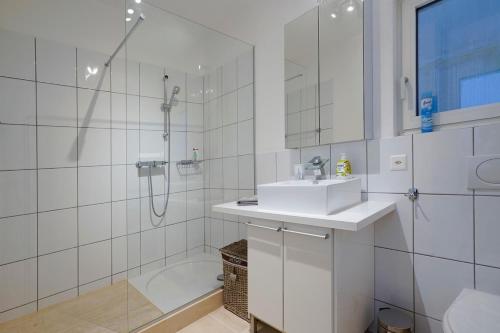卡斯拉诺The Glass House & SPA的白色的浴室设有水槽和淋浴。