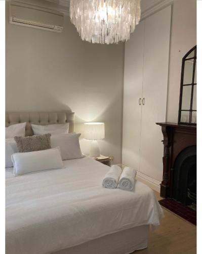 墨尔本The Richmond Cottage的卧室配有白色床和毛巾