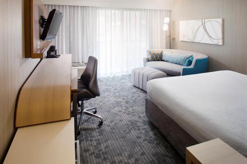 桑兹顿里士满机场万怡酒店的酒店客房配有一张床和一张书桌及一台电视